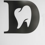 Simple black and white tooth design within letter D, ideal for dental branding.